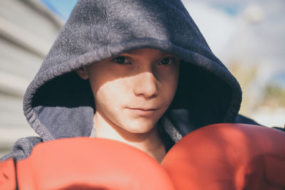 Boy wearing boxing glove while standing outdoors