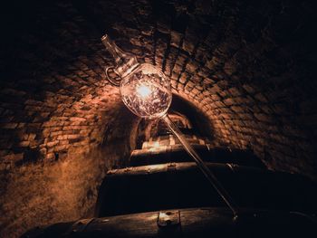 Low angle view of illuminated lamp hanging on wall