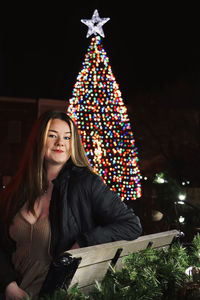 Portrait of young woman with christmas tree