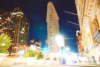 Low angle view of illuminated buildings against sky at night