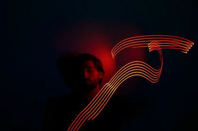 Close-up of man with illuminated lights against wall