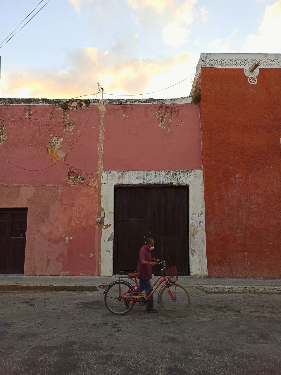 MAN RIDING BICYCLE ON BUILDING IN CITY AGAINST SKY