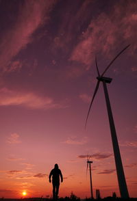 Silhouette man standing on shore against sky during sunset