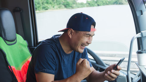 Young man using mobile phone while sitting in car