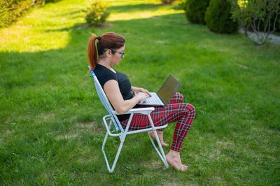 Woman using phone while sitting on chair