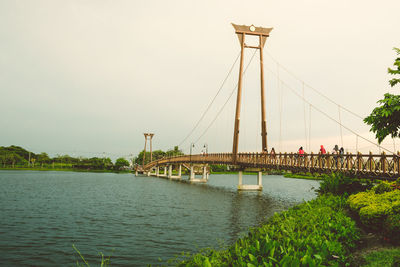 Bridge over river against sky in city