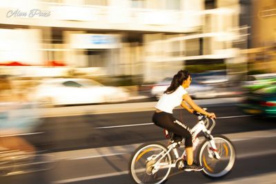 Blurred motion of person riding bicycle on city street