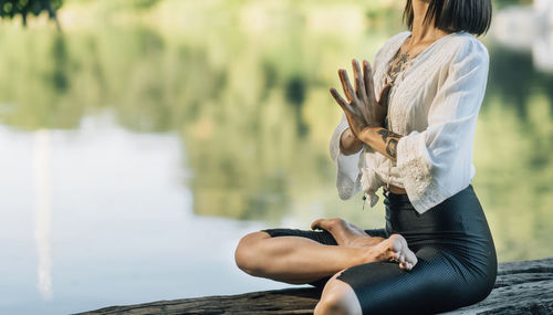 Meditation in nature. woman sitting in lotus position with hands in prayer position meditating