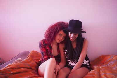 Young women sitting in bed together