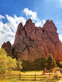 People on rock formations against sky