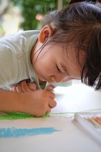 Close-up of girl coloring on paper at home