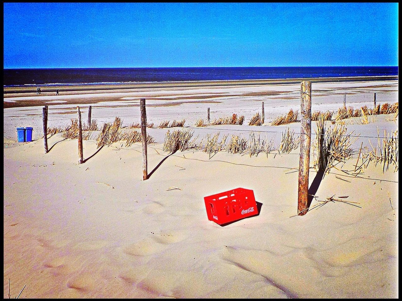 beach, sand, horizon over water, sea, transfer print, shore, auto post production filter, text, blue, western script, clear sky, day, wall - building feature, no people, copy space, outdoors, absence, red, communication, nature