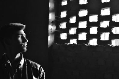 Portrait of young man looking away against wall