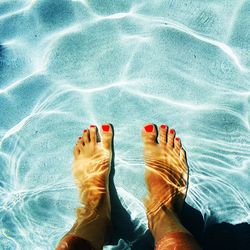 Low section of woman relaxing in swimming pool