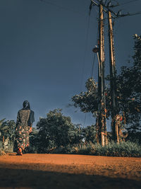 Rear view of man on field against sky