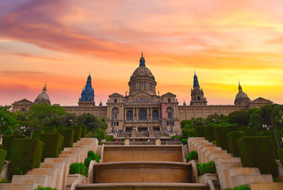 View of temple against building during sunset