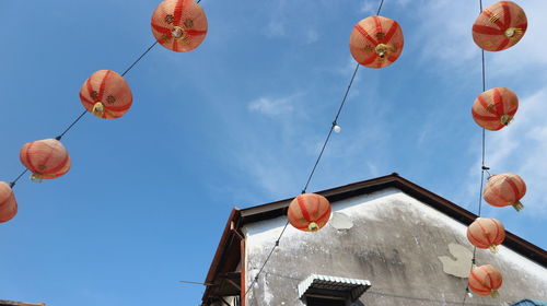 Low angle view of lanterns hanging against sky