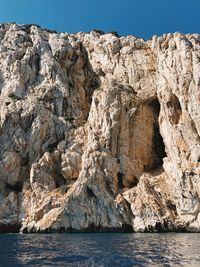Rock formations in sea against sky