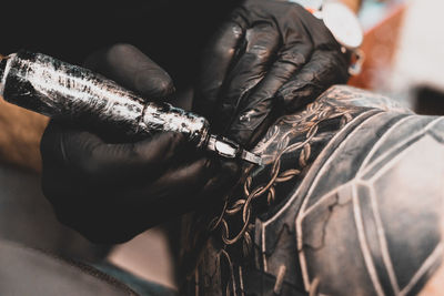 Midsection of man getting tattoo