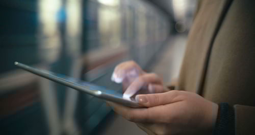 Midsection of man using mobile phone in bus
