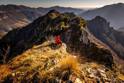 Person on rock against mountains