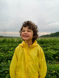 Cute boy smiles at strawberry field