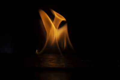 Close-up of burning candle in darkroom