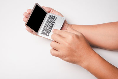 Midsection of man holding mobile phone against white background