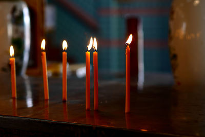 Close-up of illuminated candles in temple