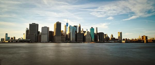 Modern buildings in city against cloudy sky