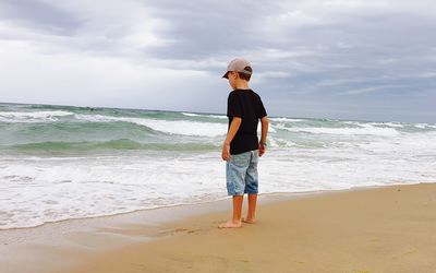 Full length of man standing on beach against sky