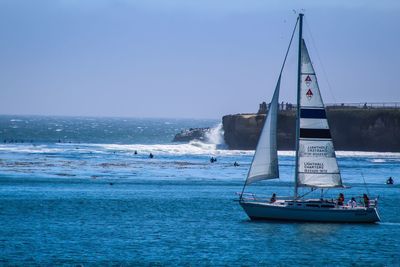 Sailboat sailing on sea against clear sky