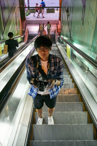 Rear view of man on escalator at railroad station