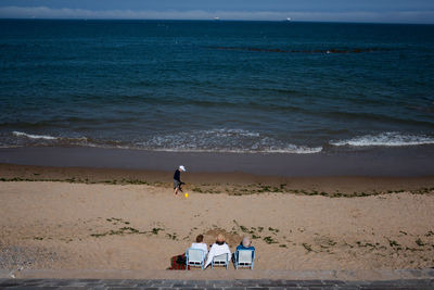 People at beach against sky