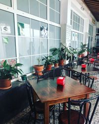 Empty chairs and tables in glass window