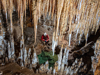 High angle view of man crouching in cave