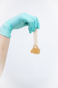 Midsection of woman holding ice cream against white background