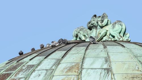 Low angle view of statue against clear blue sky