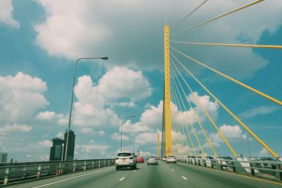 View of suspension bridge against cloudy sky