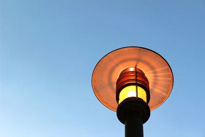 Low angle view of illuminated gas light against clear blue sky