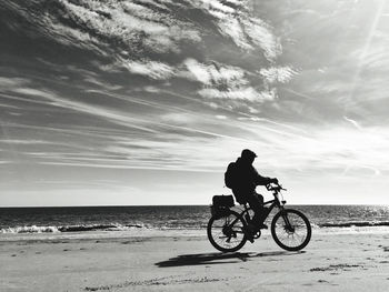 Man riding bicycle on beach