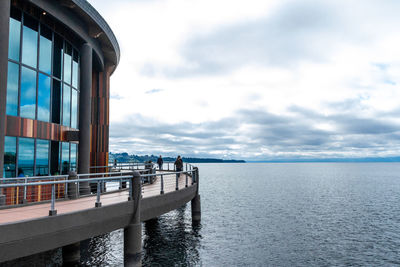 Scenic view of sea by buildings against sky