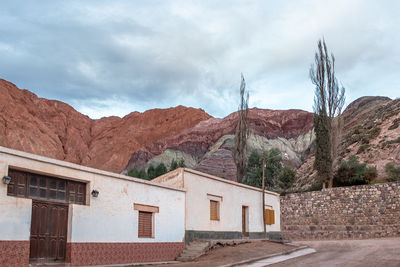 Houses by mountain against sky