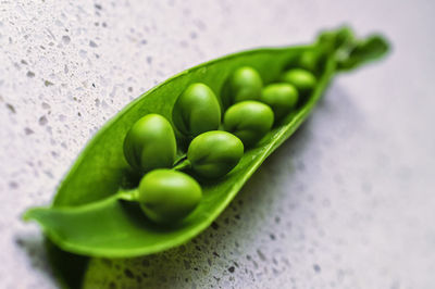 Close-up of green peas in pod on floor