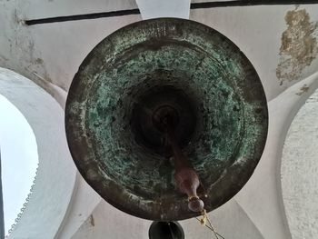 Close-up of rusty wheel against wall