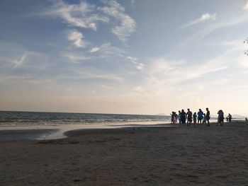 People on beach against sky