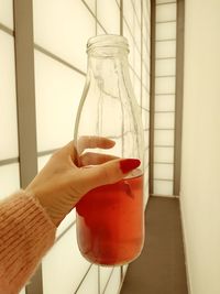 Close-up of hand holding drink on table