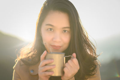 Portrait of young woman drinking coffee