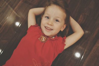 Portrait of smiling girl lying on floor