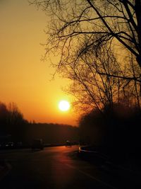 Cars on road against sky during sunset